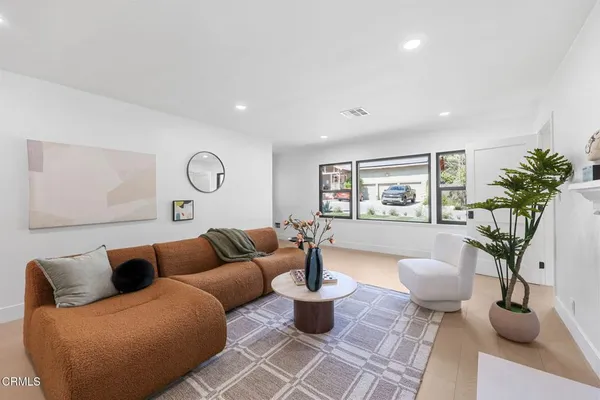 a living room with furniture potted plant and a window