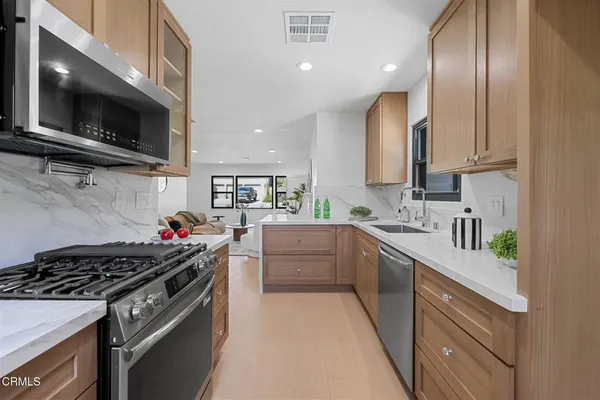 a kitchen with stainless steel appliances granite countertop a sink and a stove