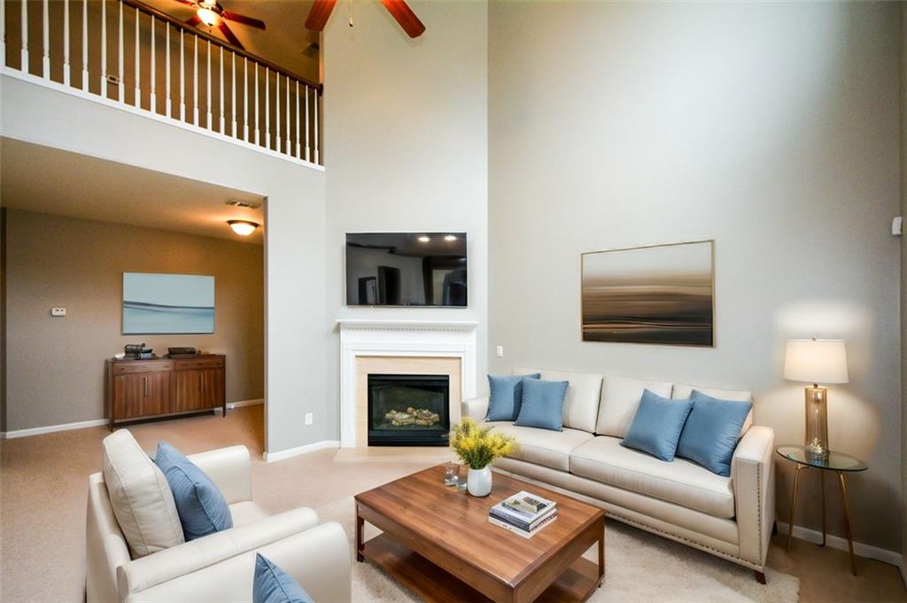 a living room with furniture a flat screen tv and a fireplace