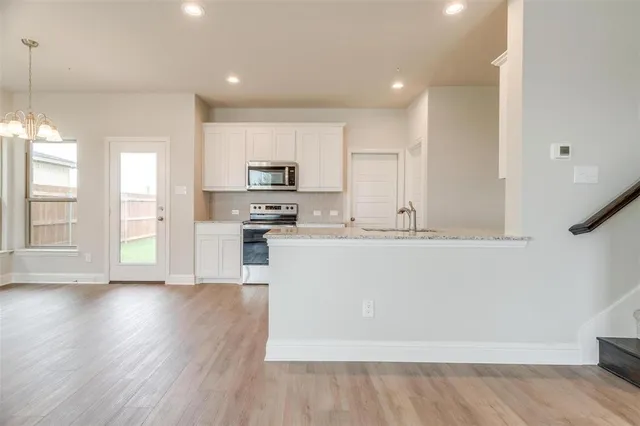 a view of a kitchen with a stove cabinets and wooden floor