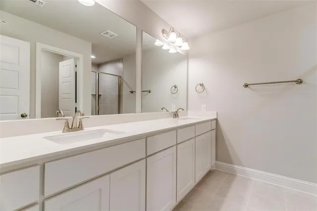 a bathroom with a double vanity sink mirror and shower