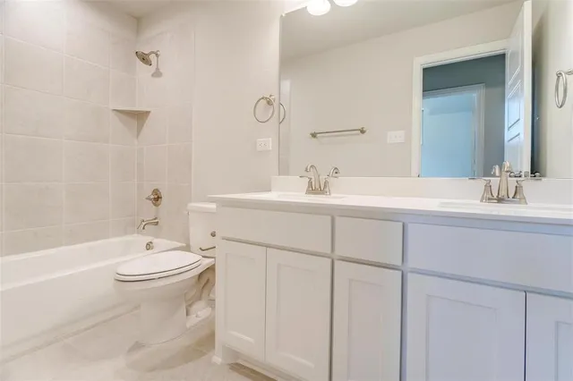 a bathroom with a double vanity sink toilet mirror and bathtub
