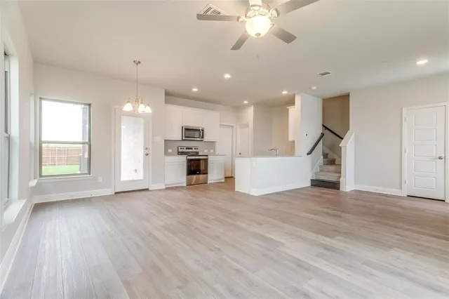 a view of an empty room with kitchen appliances and a window
