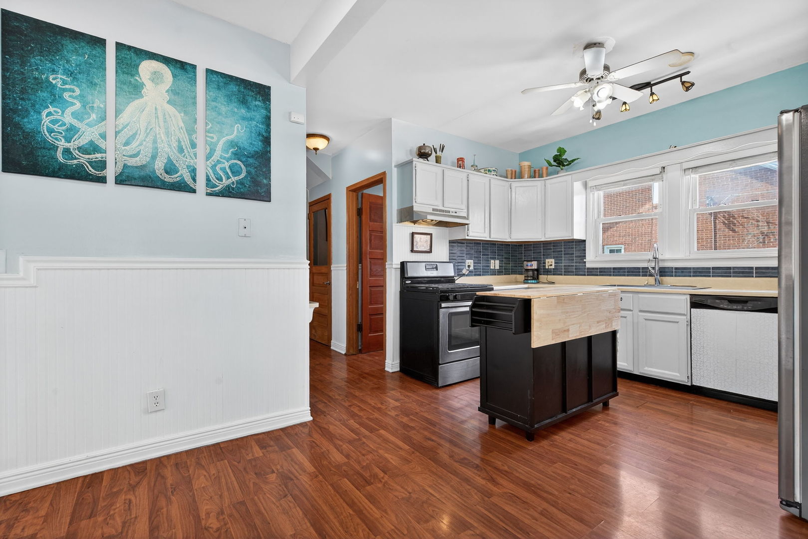 206 West Delaware Street Dwight, IL 60420 - Photo 19 of 42 a kitchen with granite countertop a stove a sink dishwasher a refrigerator and a dining table with wooden floor