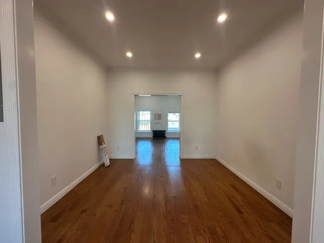 a view of empty room with wooden floor