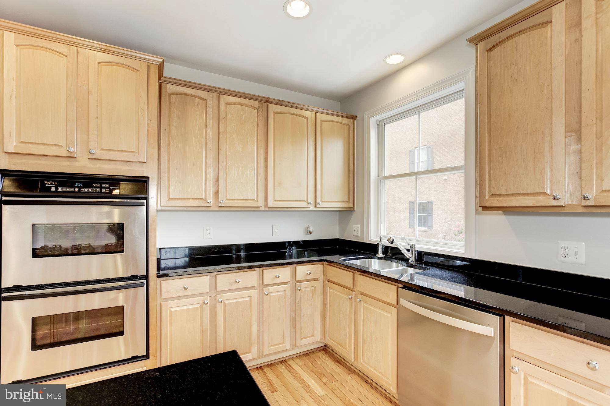 2316 Plyers Mill Road Silver Spring, MD 20902 - Photo 11 of 24 a kitchen with granite countertop white cabinets and black appliances