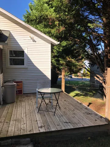 a view of a roof deck with wooden floor and seating space