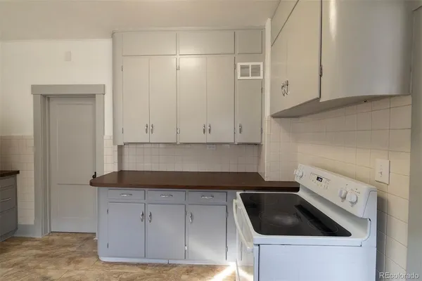 a kitchen with granite countertop white cabinets and a stove