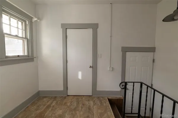 a view of a hallway with wooden floor and a window