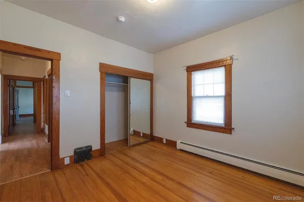 an empty room with window and wooden floor
