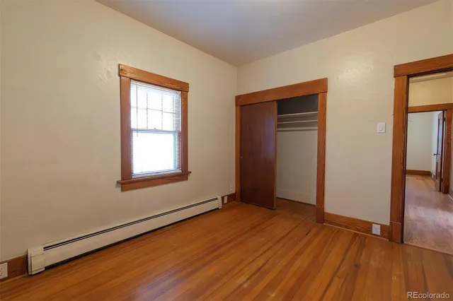 an empty room with wooden floor and closet