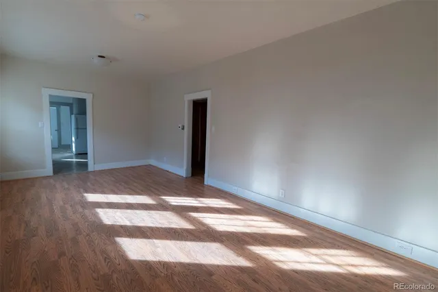 a view of empty room with wooden floor
