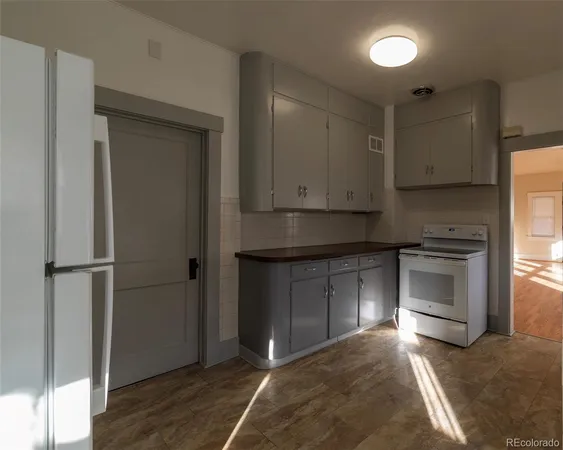 a kitchen with a refrigerator and a stove top oven