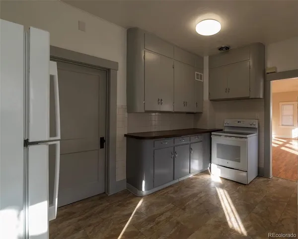 a kitchen with a refrigerator and a stove top oven