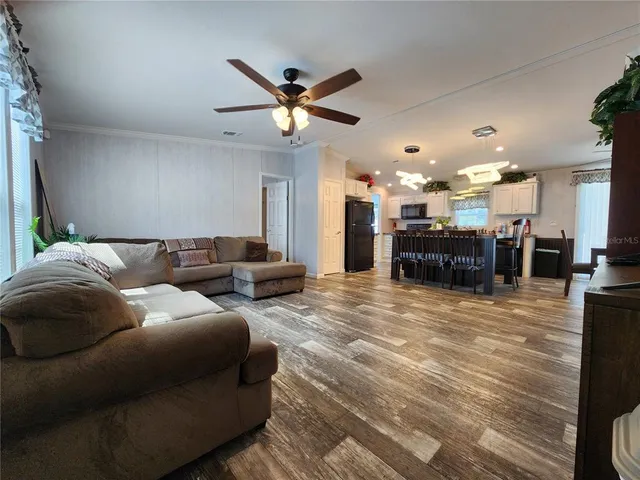 a living room with furniture and a dining table with kitchen view