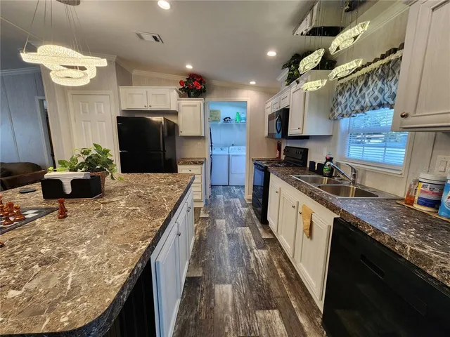 a kitchen with stainless steel appliances kitchen island granite countertop a sink stove and refrigerator