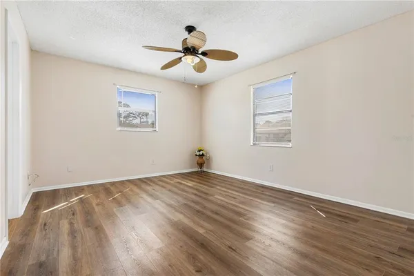 a view of empty room with wooden floor
