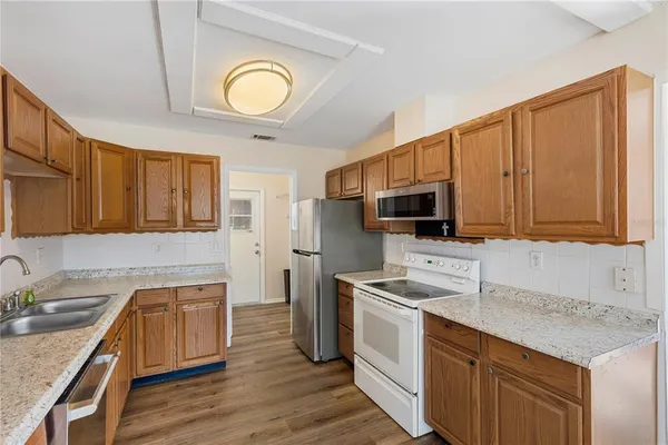 a kitchen with stainless steel appliances granite countertop a sink stove microwave and refrigerator