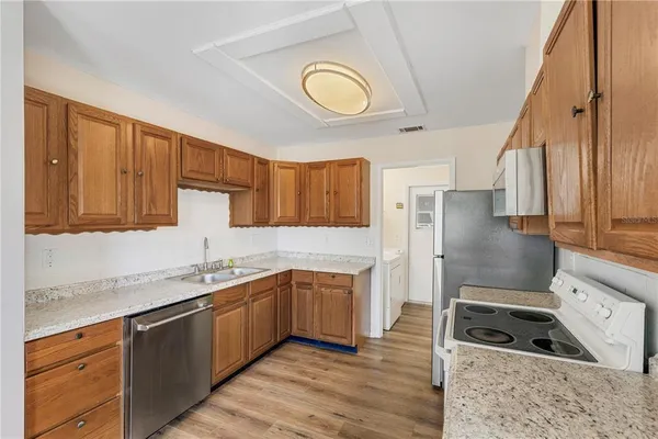 a kitchen with stainless steel appliances granite countertop a sink a stove and a refrigerator