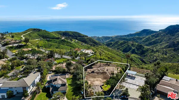 an aerial view of a houses with a yard