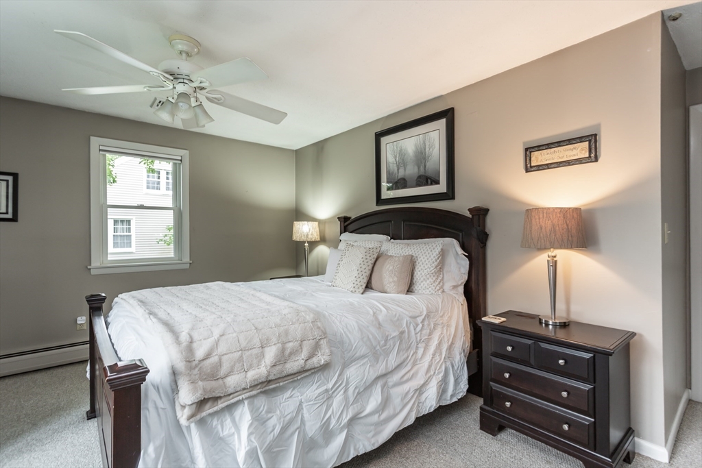 127 Howland Road Fairhaven, MA 02719 - Photo 18 of 42 a bedroom with a bed and a chandelier