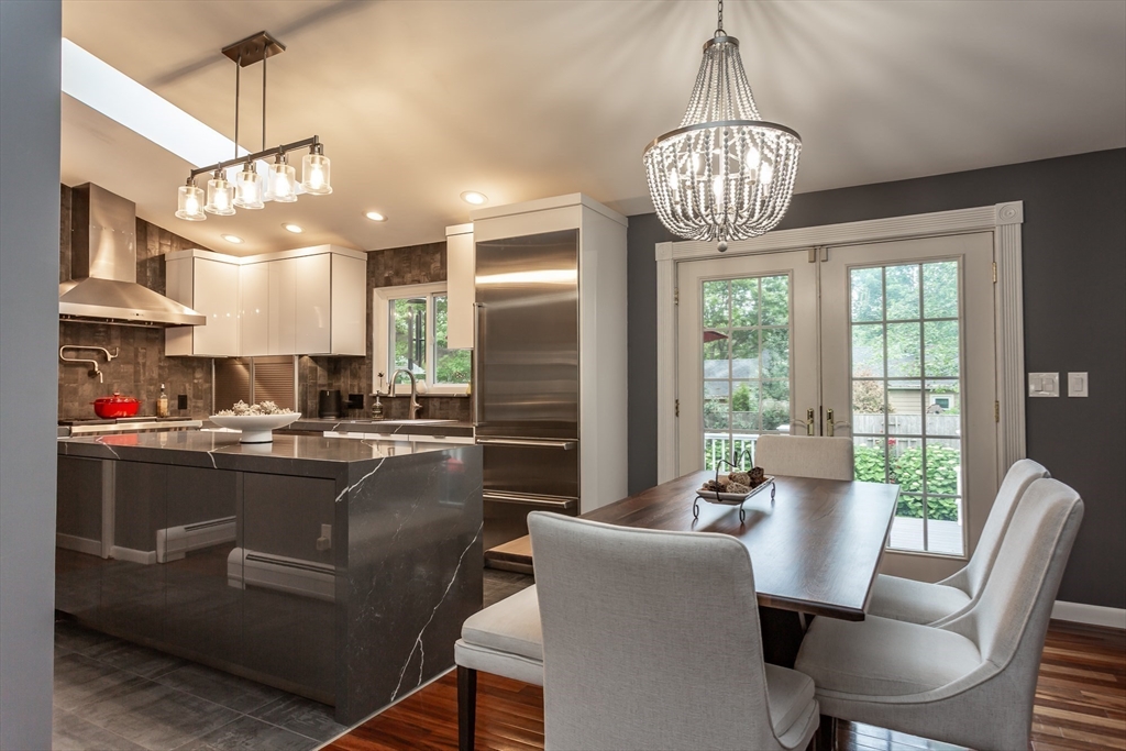 127 Howland Road Fairhaven, MA 02719 - Photo 9 of 42 a dining room with stainless steel appliances granite countertop furniture a fireplace and a chandelier