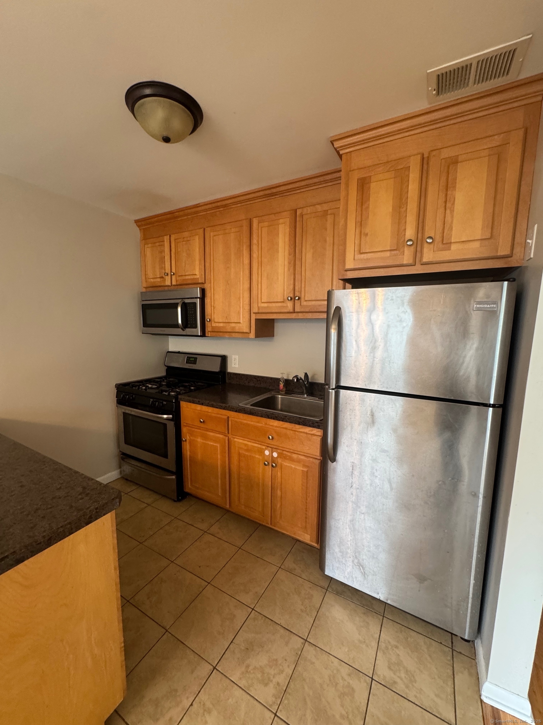 12 Cedar Court, Unit I East Haven, CT 06513 - Photo 3 of 9 a kitchen with stainless steel appliances granite countertop a refrigerator a sink a stove a microwave and cabinets