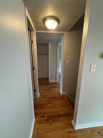 a view of a hallway with wooden floor and staircase
