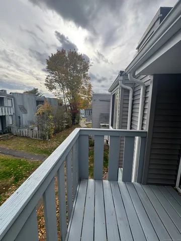 a view of a balcony with wooden floor and fence