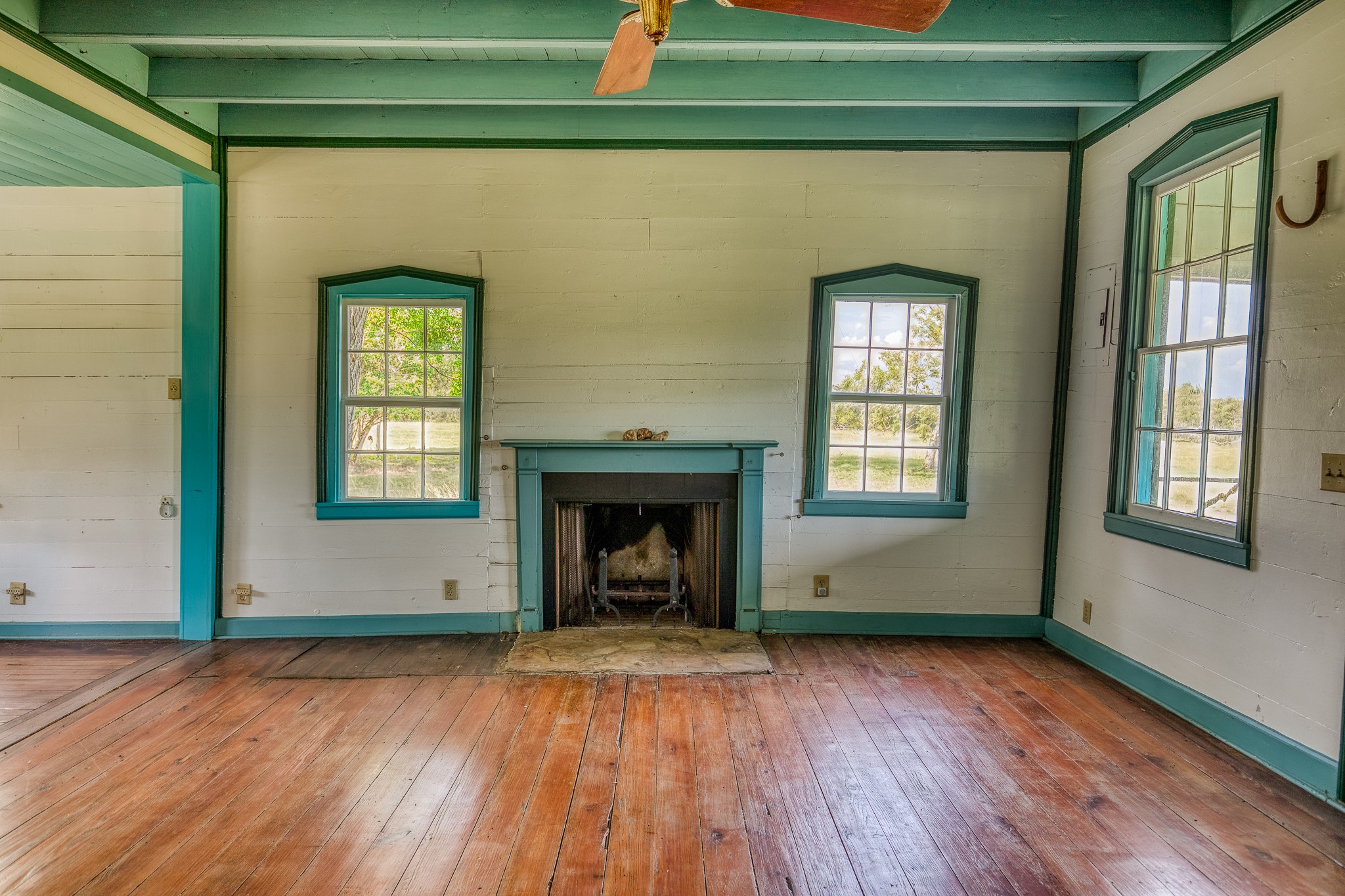 3420 Rohde Road Round Top, TX 78954 - Photo 18 of 28 an empty room with wooden floor a fireplace and windows