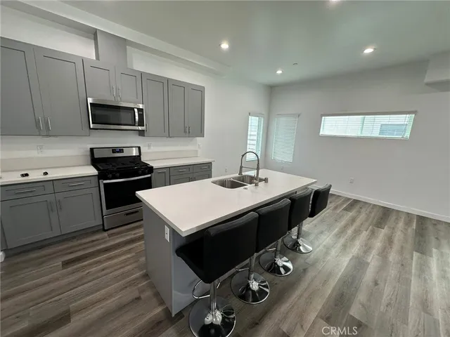 a kitchen with a sink refrigerator and cabinets