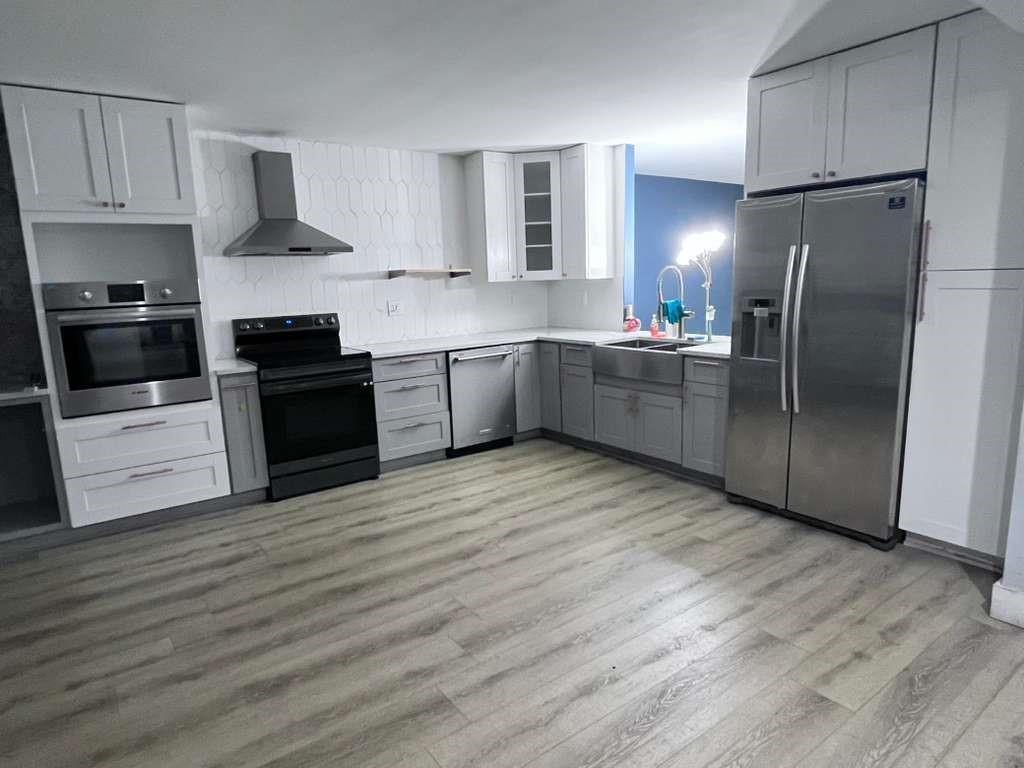 20441 Northeast 30th Avenue, Unit 110 Miami, FL 33180 - Photo 13 of 16 a kitchen with granite countertop a refrigerator and a stove top oven