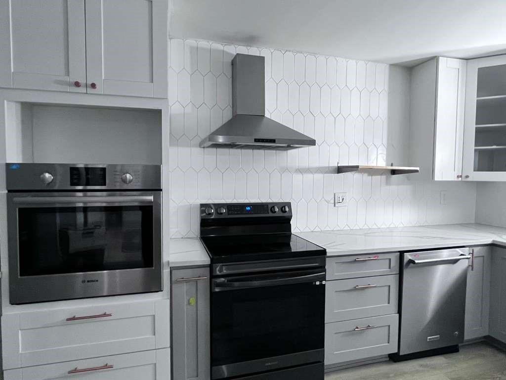 20441 Northeast 30th Avenue, Unit 110 Miami, FL 33180 - Photo 15 of 16 a kitchen with stainless steel appliances granite countertop a stove and a microwave