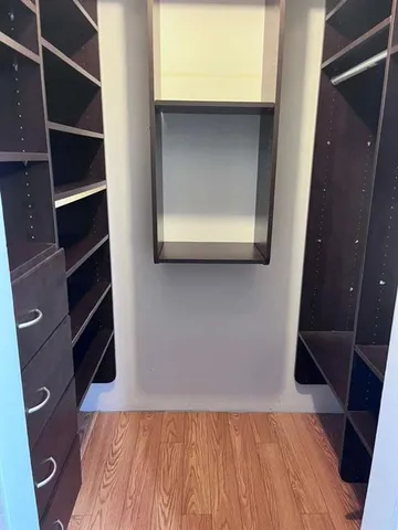 a view of walk in closet with clothes and shoes