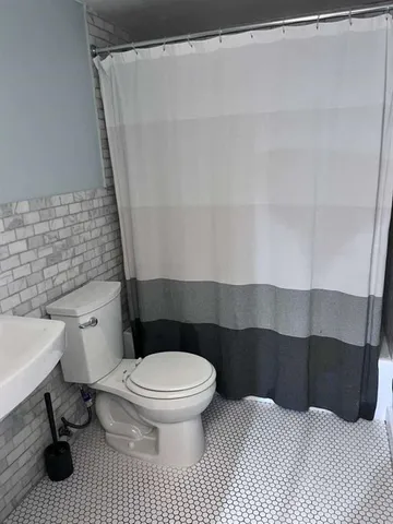a bathroom with a toilet and a shower