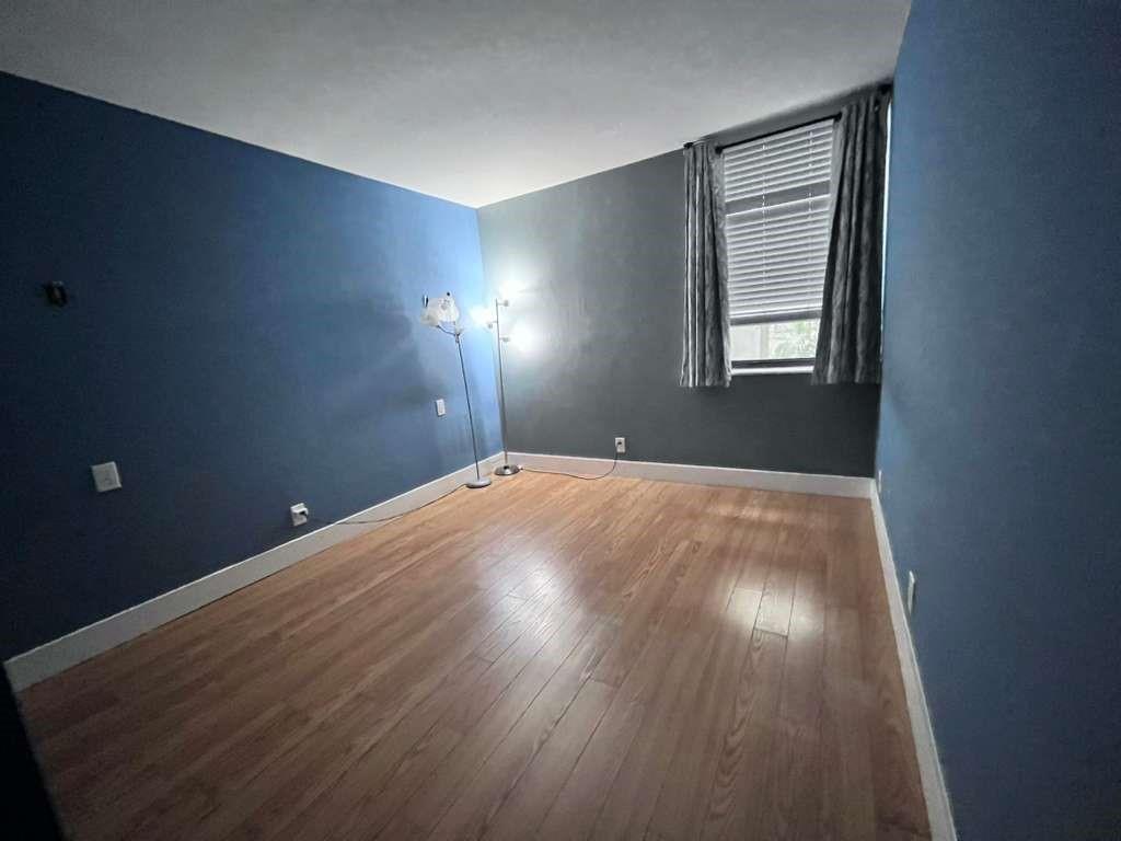 20441 Northeast 30th Avenue, Unit 110 Miami, FL 33180 - Photo 7 of 16 an empty room with wooden floor and windows
