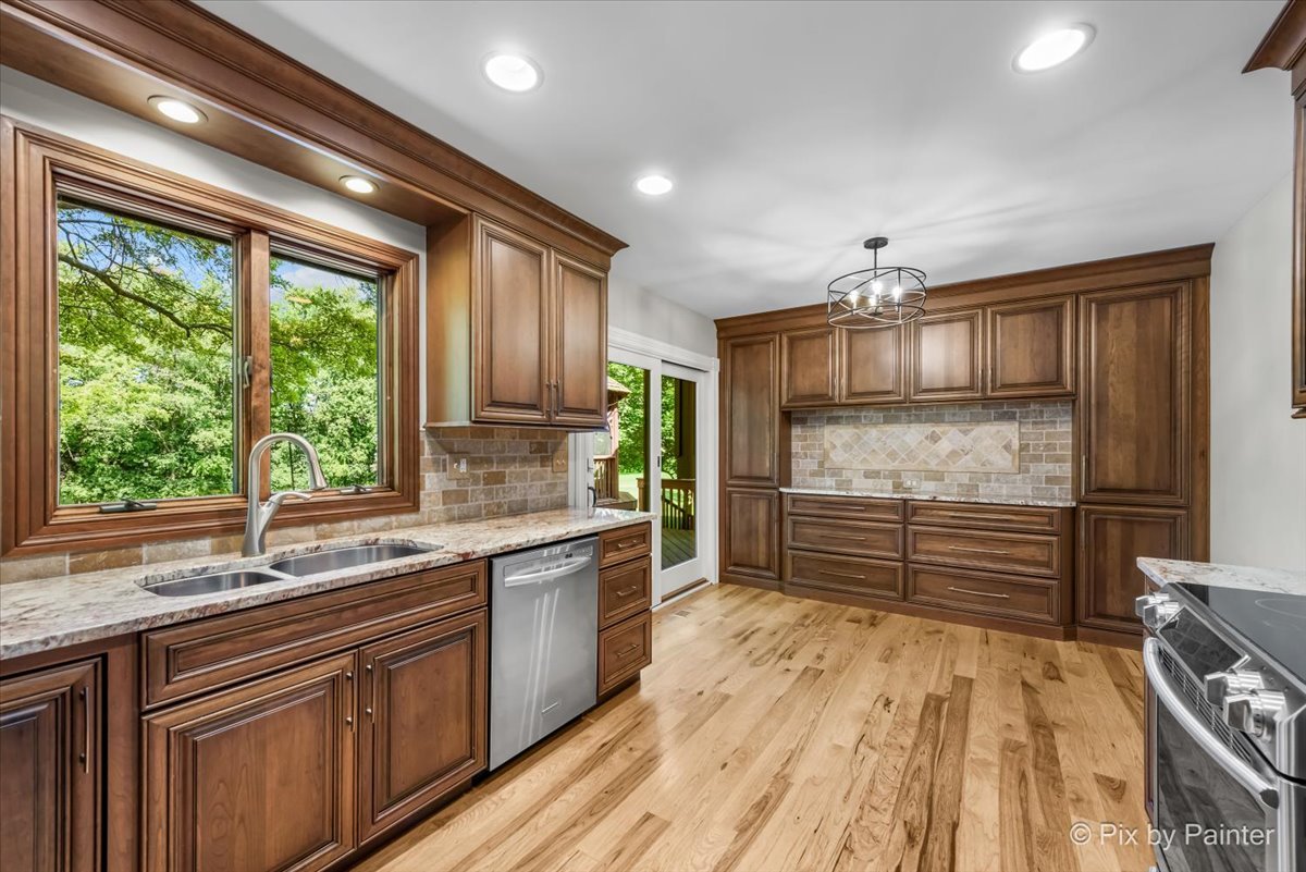 6403 Ridgeview Drive Huntley, IL 60142 - Photo 8 of 35 a kitchen with stainless steel appliances granite countertop a sink stove and refrigerator