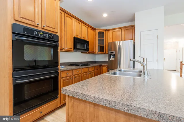 a kitchen with stainless steel appliances granite countertop a stove microwave and sink