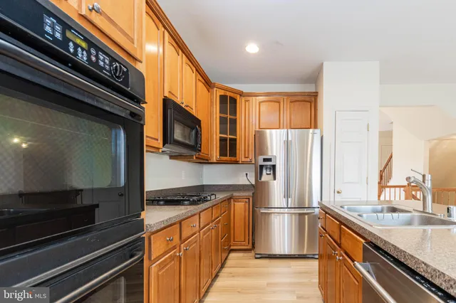 a kitchen with stainless steel appliances granite countertop a refrigerator and a stove top oven