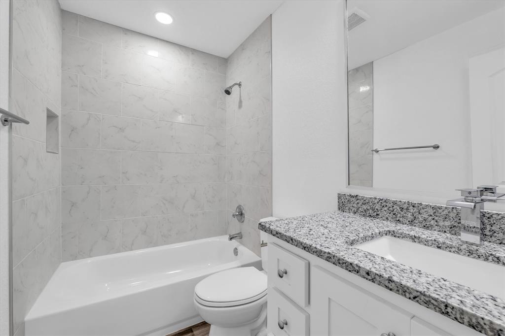 204 North Wiebusch Street Riesel, TX 76682 - Photo 22 of 33 a bathroom with a granite countertop sink a toilet and bathtub