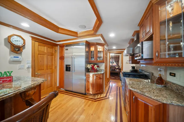 a view of a kitchen with stainless steel appliances granite countertop a refrigerator a stove and a sink