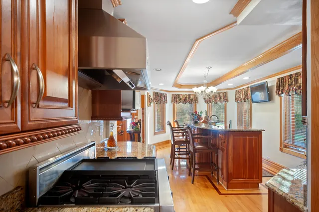 a kitchen with stainless steel appliances a stove a table and chairs