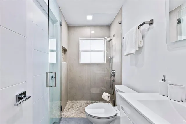 a bathroom with a toilet a sink and shower