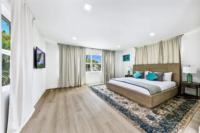 a bedroom with a large bed a rug and a window