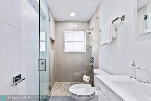 a bathroom with a toilet a sink and shower
