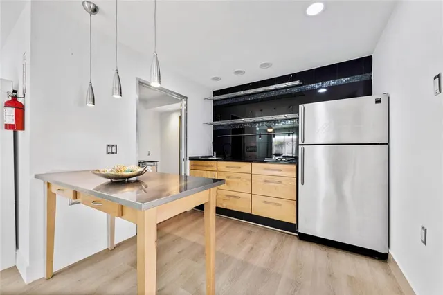a kitchen with stainless steel appliances a refrigerator and a stove top oven