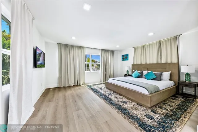 a spacious bedroom with a bed a dresser and a window