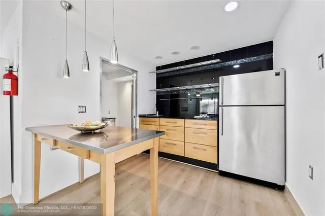 a kitchen with stainless steel appliances a refrigerator and a stove top oven
