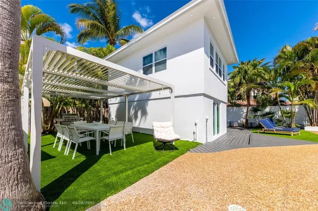 a view of a house with backyard and sitting area