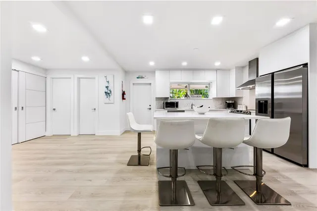 a kitchen with stainless steel appliances kitchen island granite countertop a sink and a refrigerator